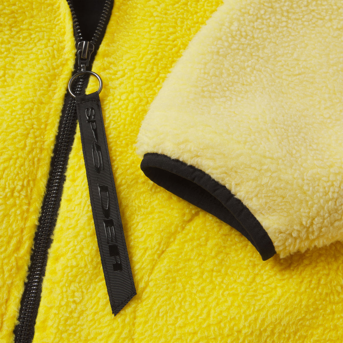 Bright yellow textured fleece jacket featuring a black front zipper with a branded SP5DER ring pull and black trim.