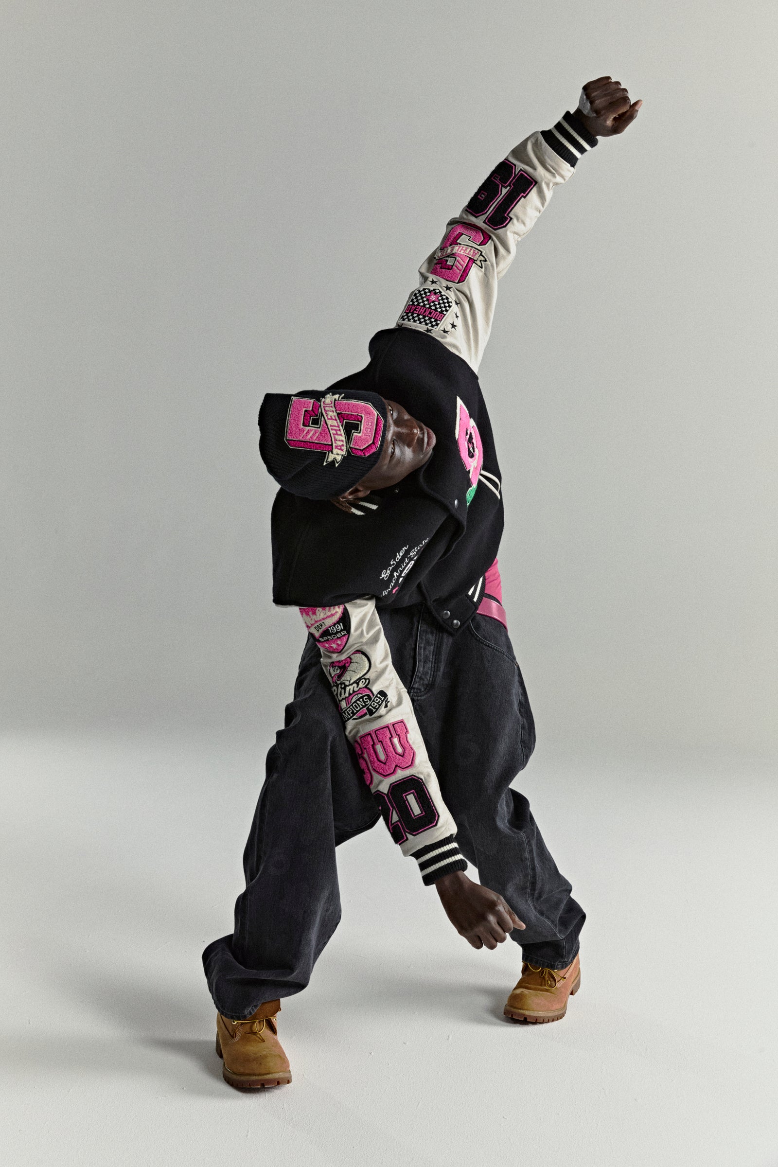 DIVISION 5 Varsity Jacket: Black wool body, cream leather sleeves with pink patches, and striped ribbed trim.