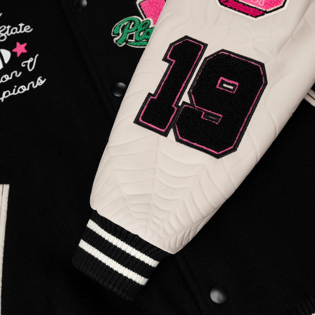 Black wool varsity jacket with cream leather sleeves, debossed web design, and embroidered "19" and patches.