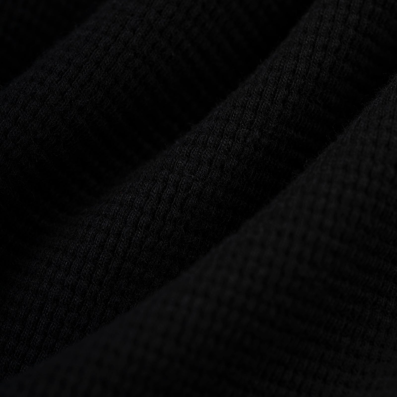 Black waffle knit thermal fabric with ribbed texture.