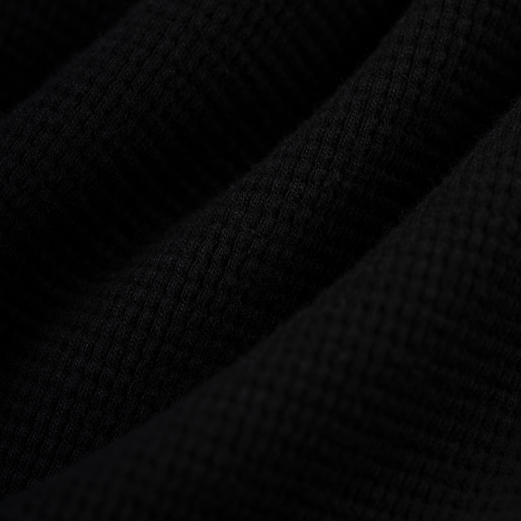 Black waffle knit thermal fabric with ribbed texture.