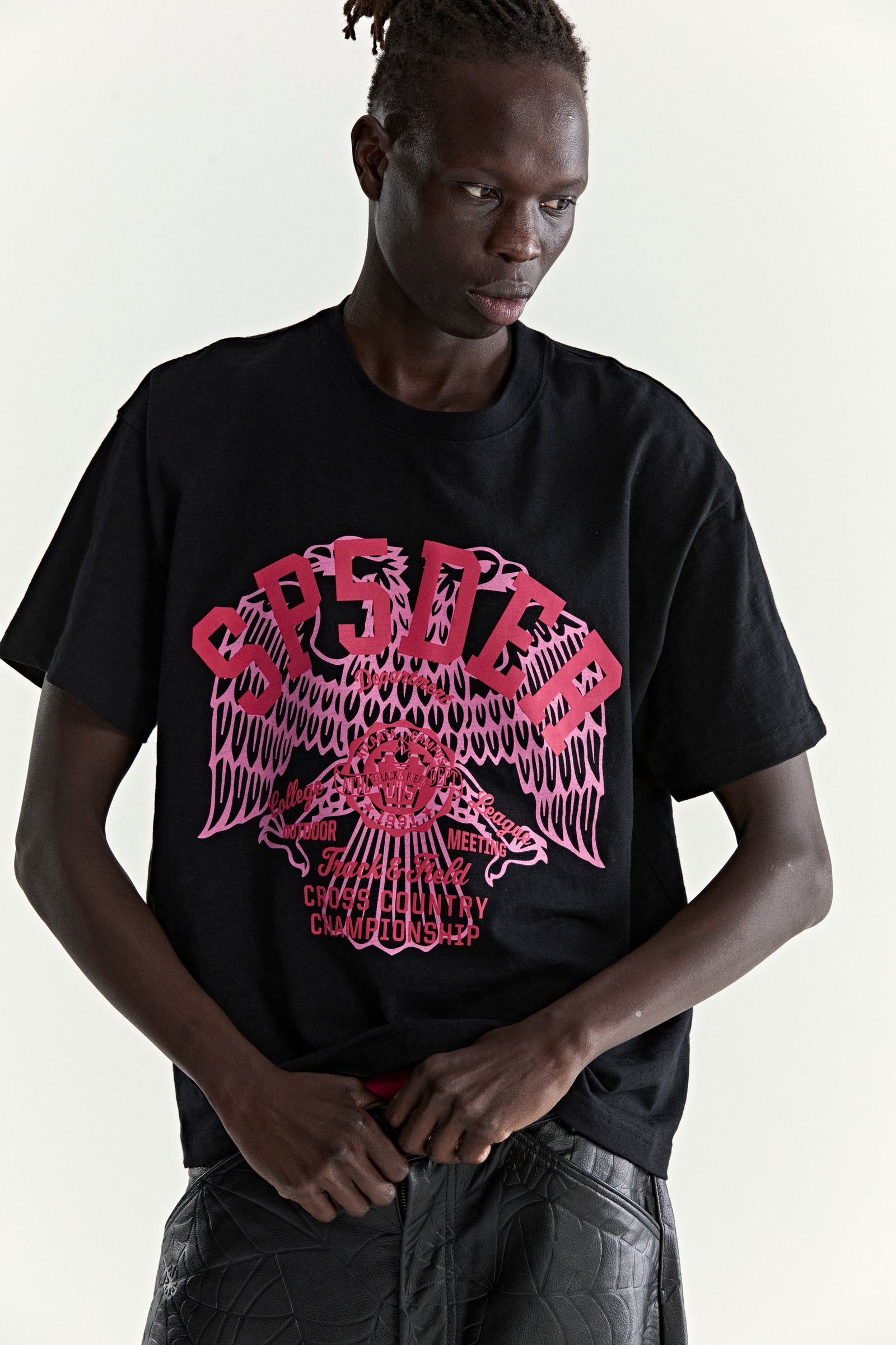 Black slub jersey tee with a large pink graphic print featuring an eagle and "CROSS COUNTRY" text.