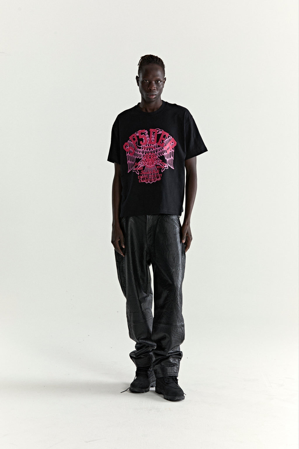 Black slub jersey tee with red eagle graphic, worn by a man with black textured pants.