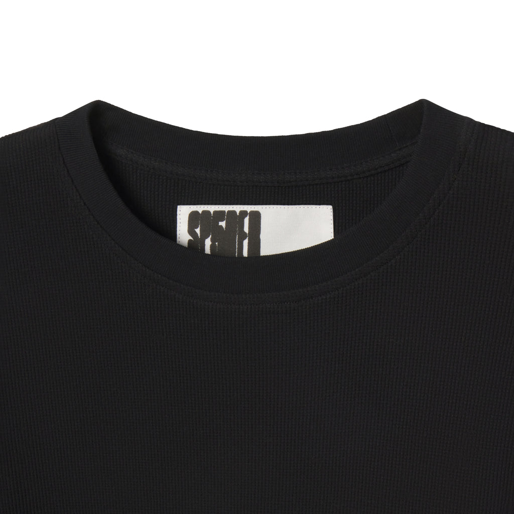 Black waffle knit thermal shirt featuring a ribbed crew neck collar and a branded interior neck label.