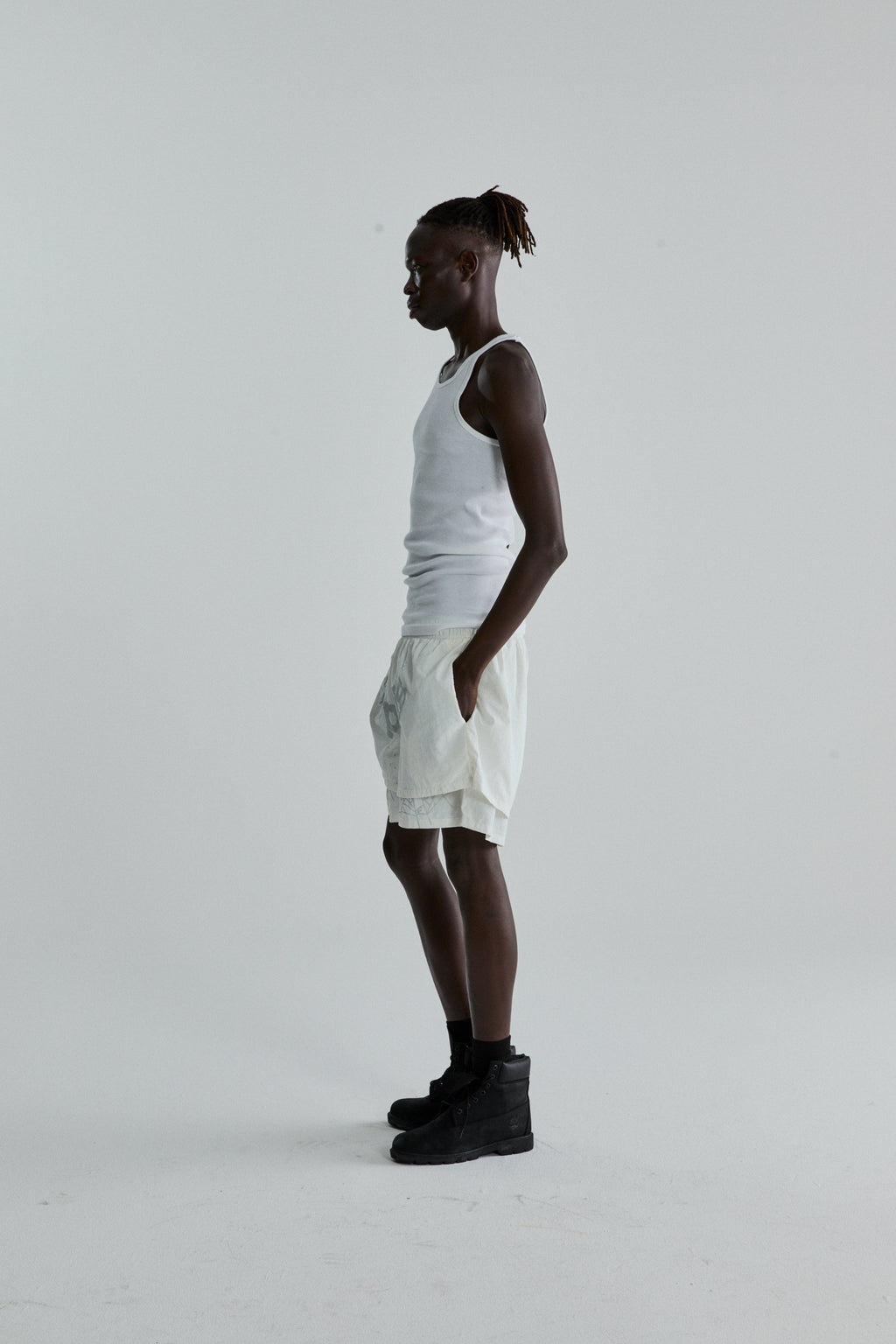 Model in white OG WEB Double Layer Short with high-low design, OG SP5DER text, and star print.