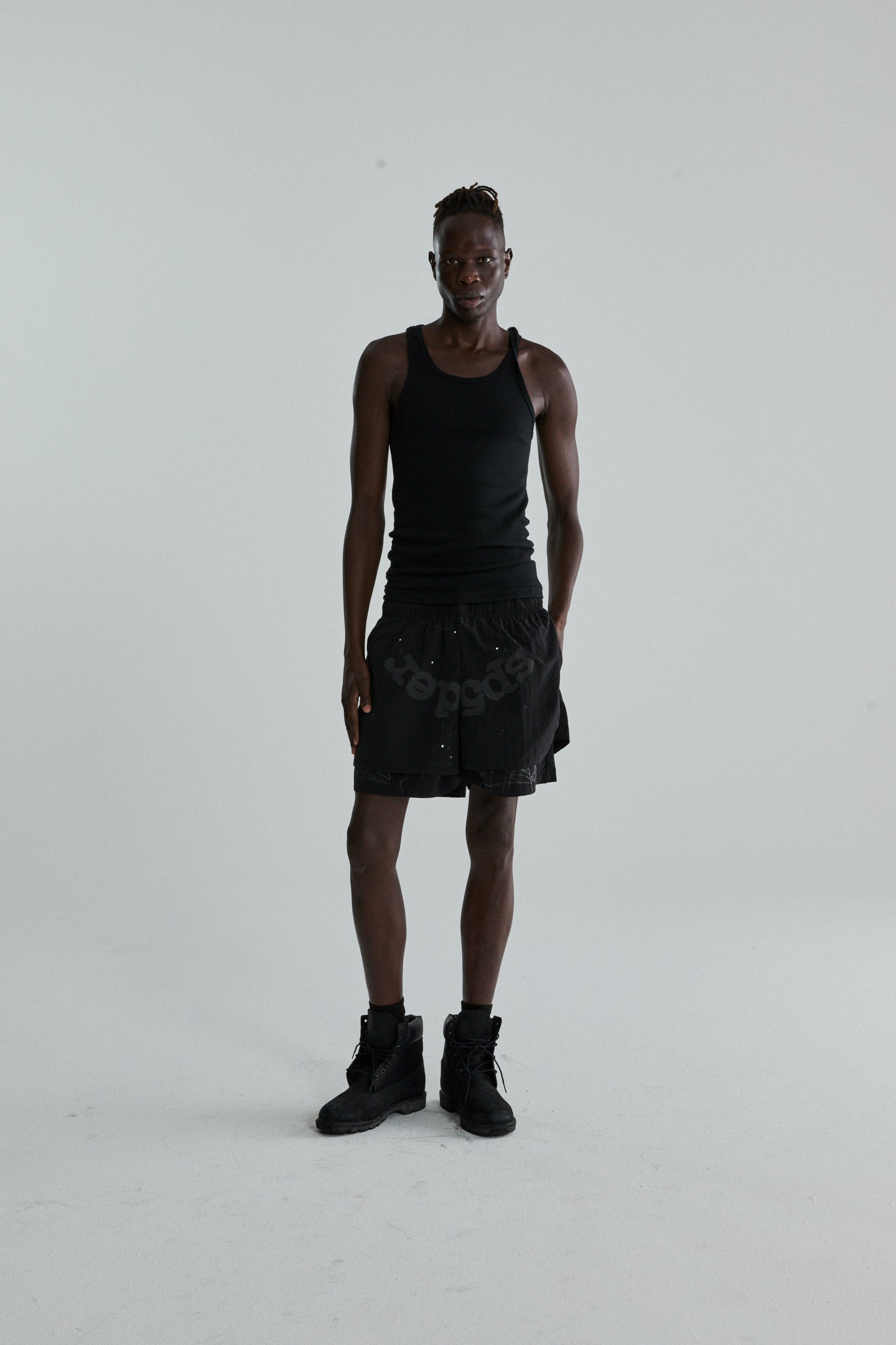 Black OG WEB Double Layer Short with OG SP5DER text and star print, worn by a model.