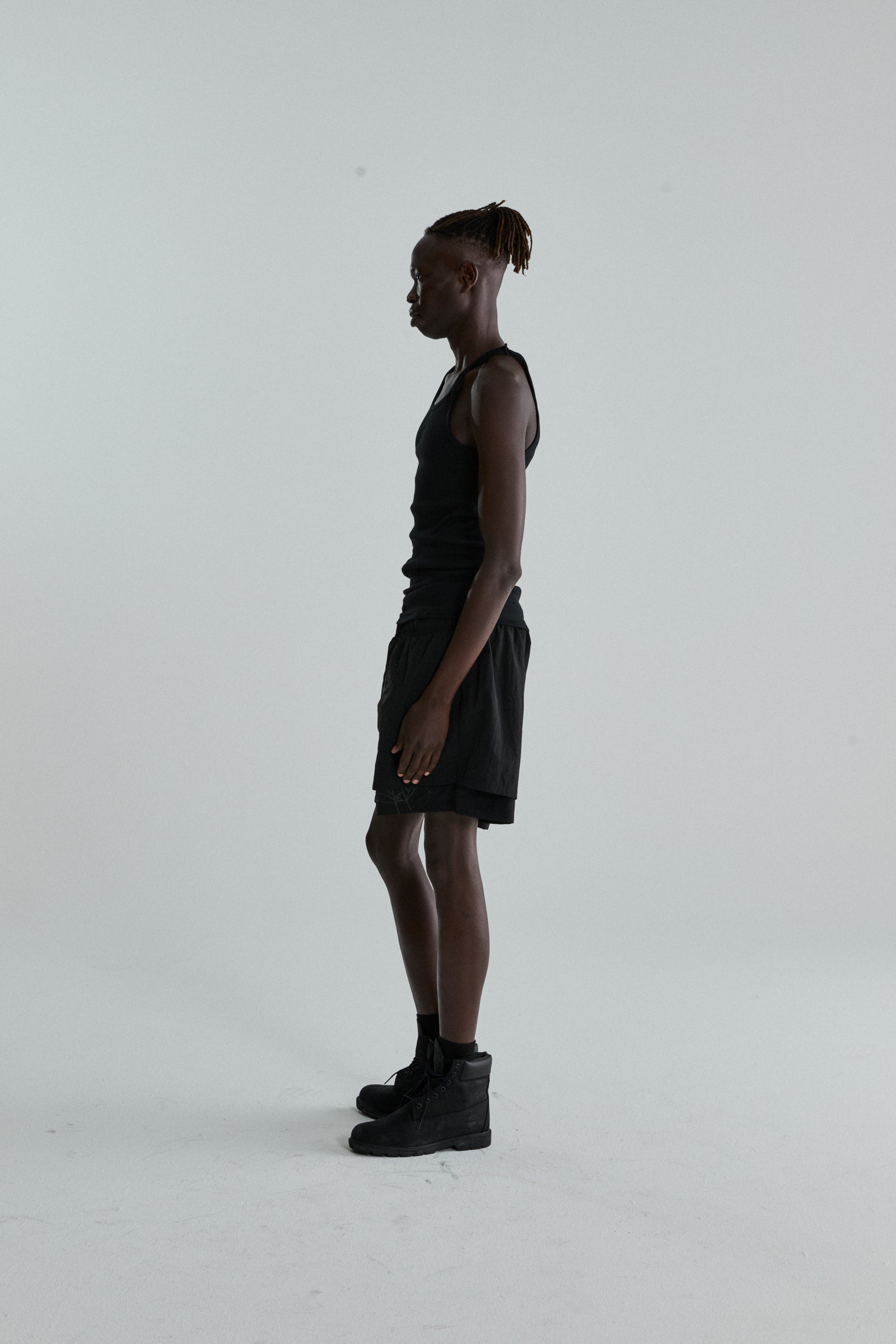 Black OG WEB Double Layer Short with high-low design and OG SP5DER text, worn by a male model.