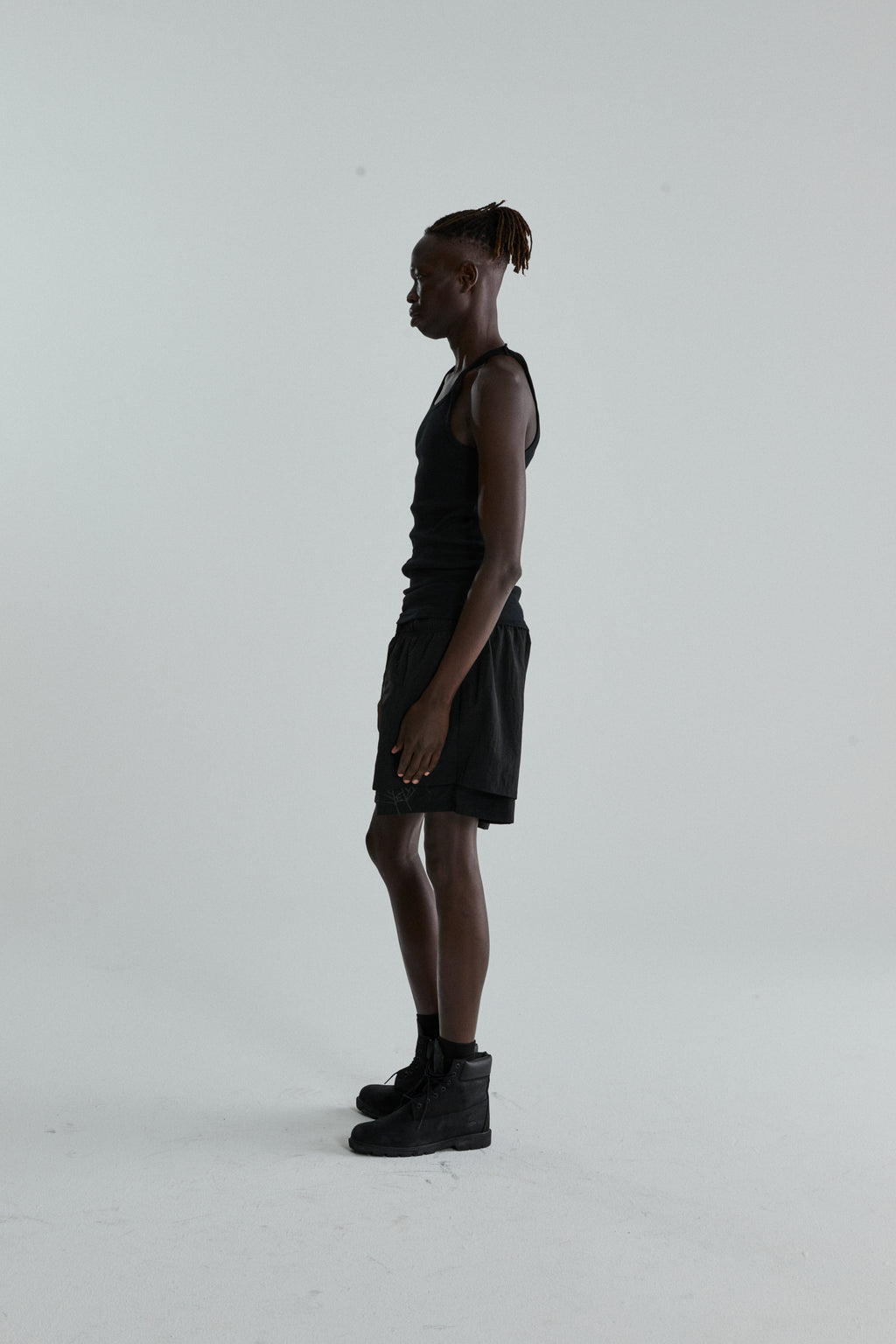 Black OG WEB Double Layer Short with high-low design and OG SP5DER text, worn by a male model.