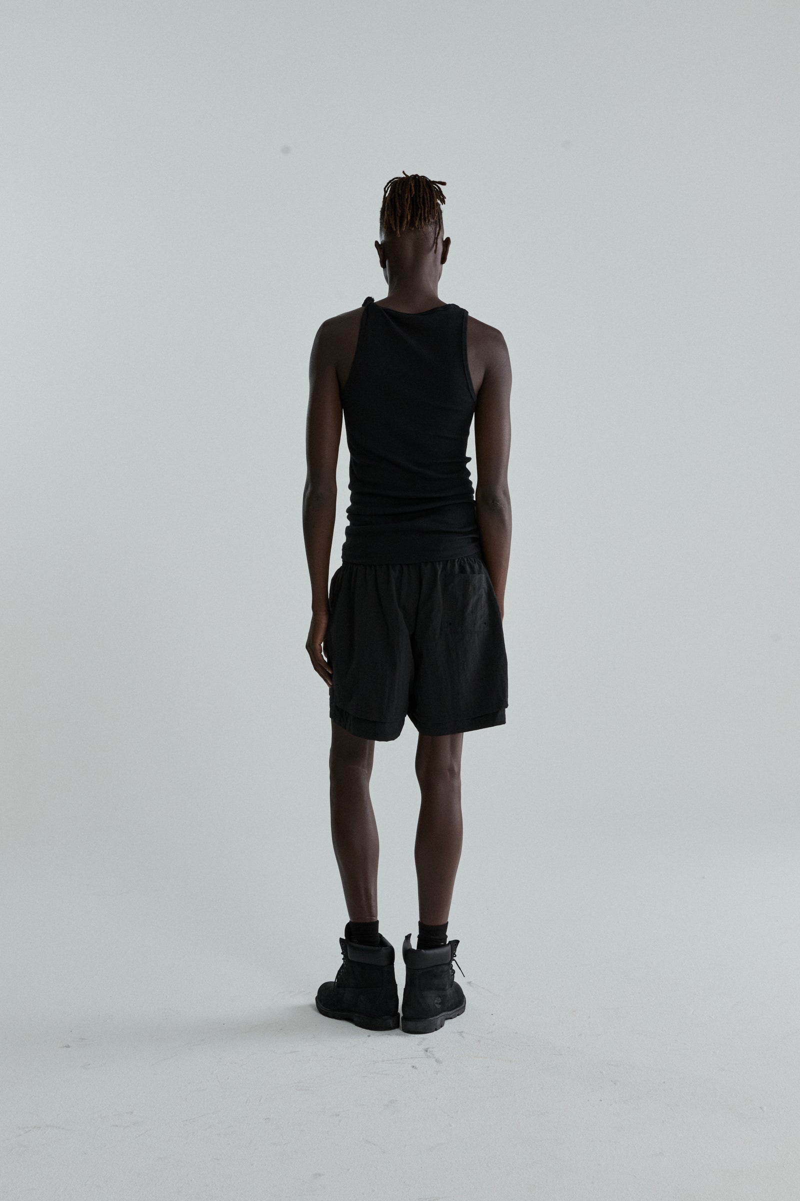 Black OG WEB Double Layer Short with high-low design and OG SP5DER text, worn by a person from behind.