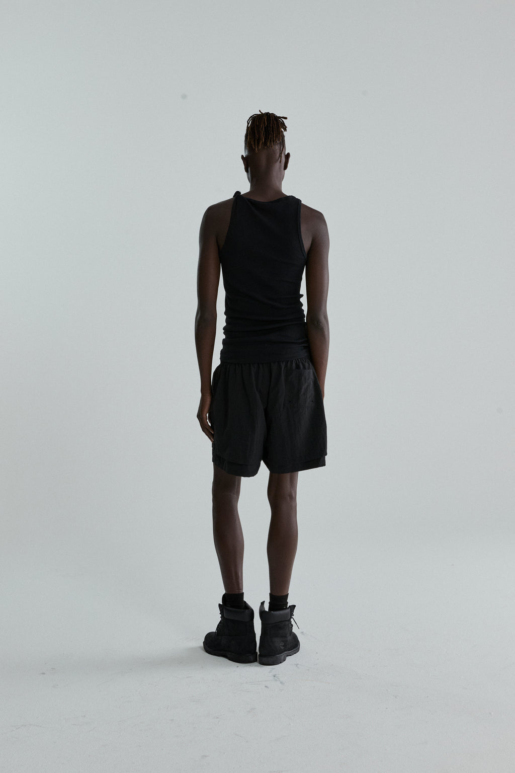 Black OG WEB Double Layer Short with high-low design and OG SP5DER text, worn by a person from behind.