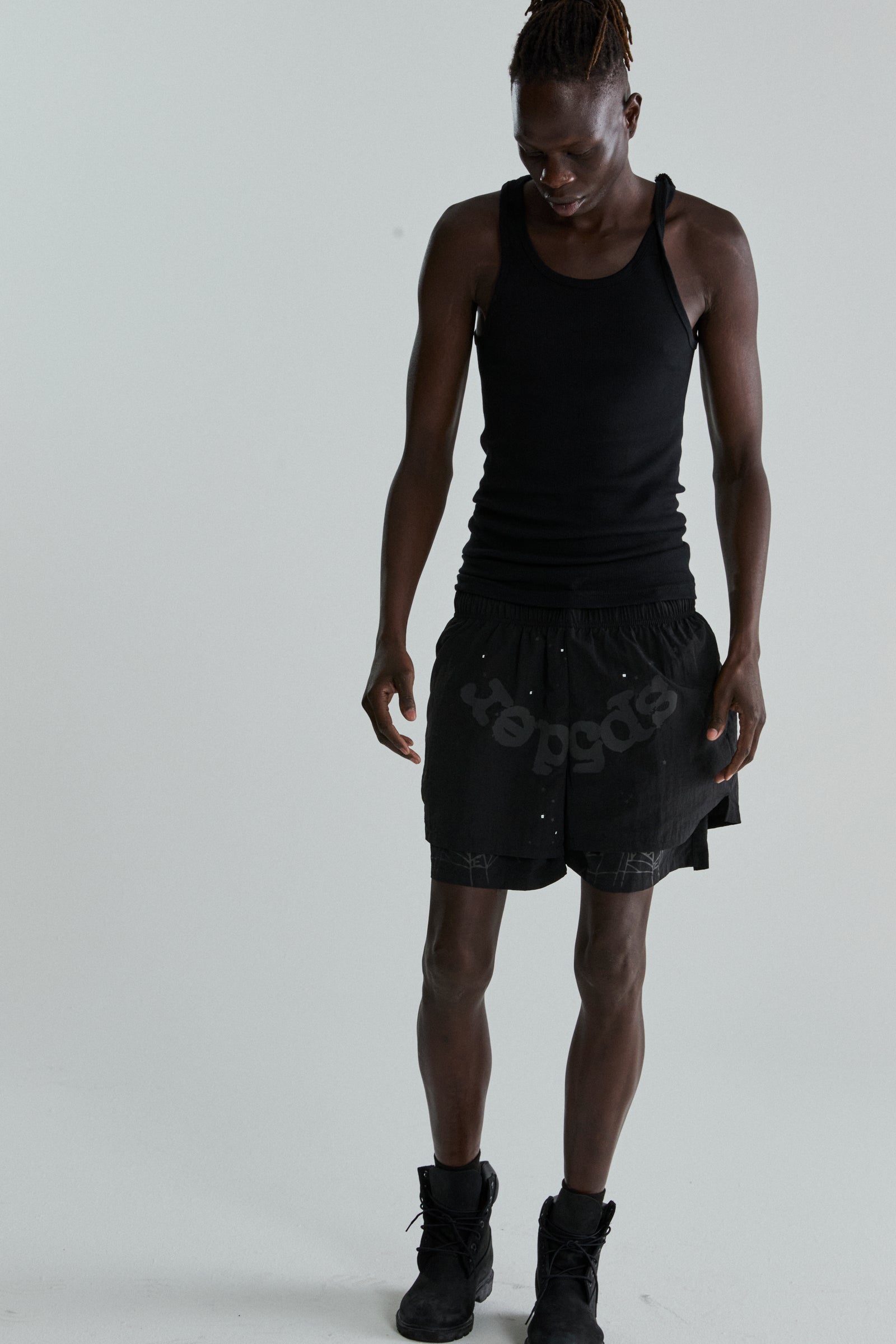 Black OG WEB Double Layer Short with SP5DER text and star print, made from water-repellent nylon.