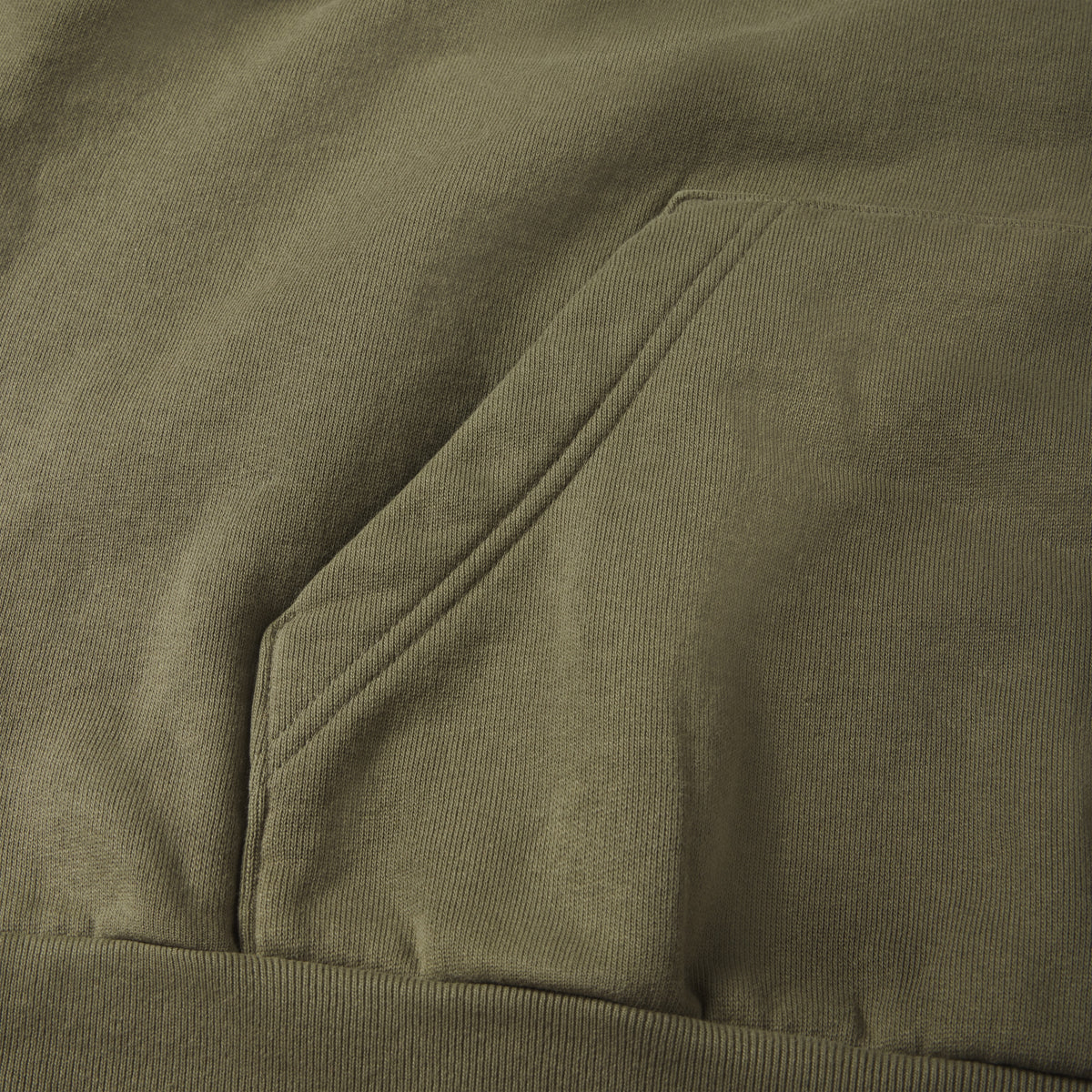 Faded olive green 13oz cotton fleece hoodie featuring a kangaroo pocket and ribbed hem detail.