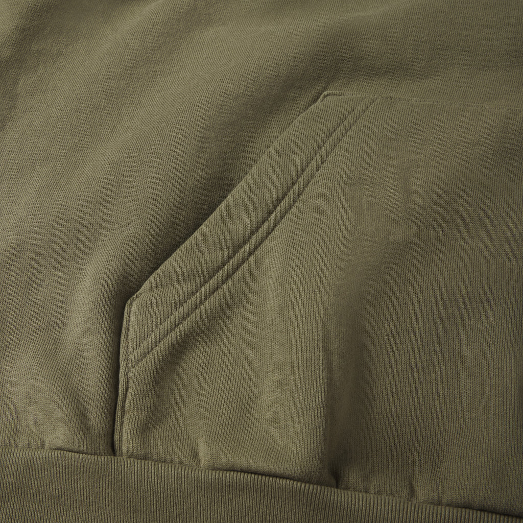 Faded olive green 13oz cotton fleece hoodie featuring a kangaroo pocket and ribbed hem detail.