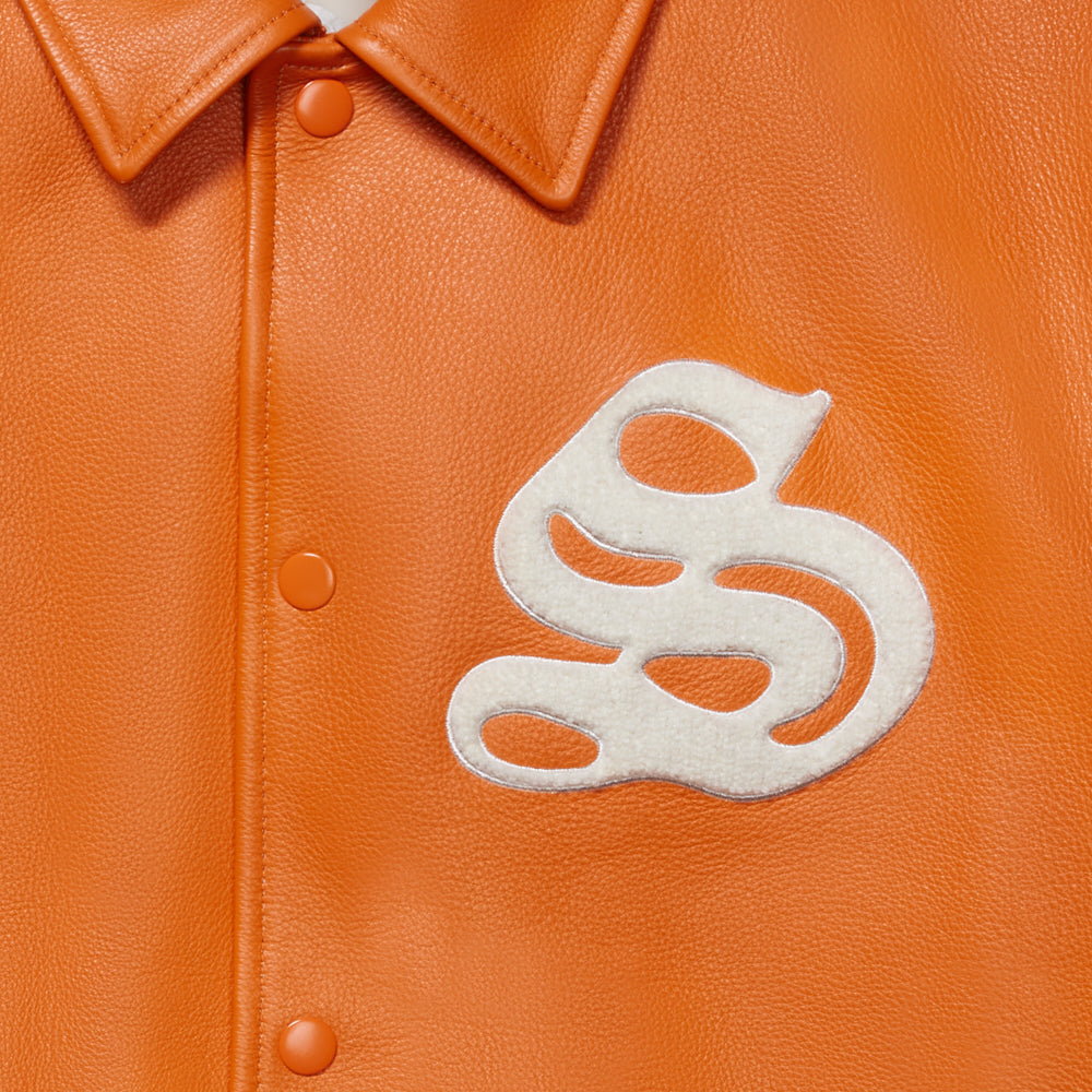 Orange cowskin leather varsity jacket with a white chenille 'S' patch and snap-button closure.