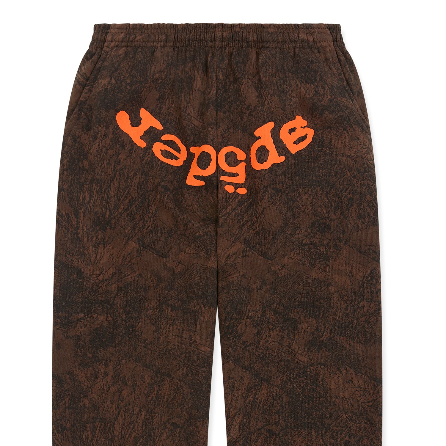 Brown tree camo sweatpants with orange SP5DER text at crotch, elastic waistband, and cuffs.