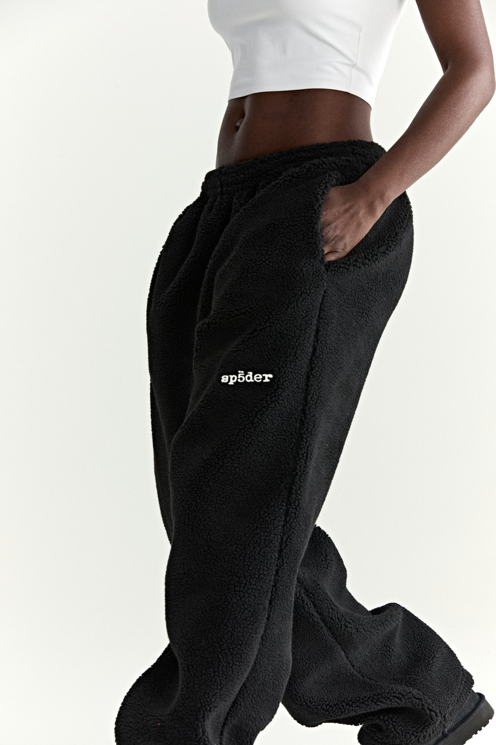 Black teddy fleece pant with white "sp5der" logo, elasticized waistband, and straight leg fit.