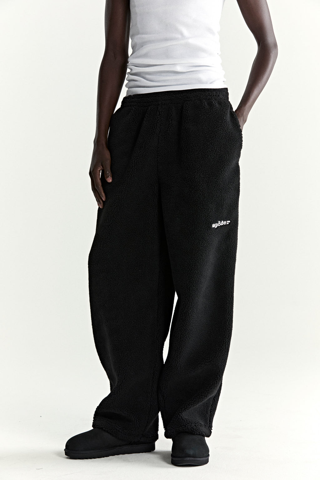 Black teddy fleece pant with white "spider" logo, elasticized waistband, and straight leg fit.