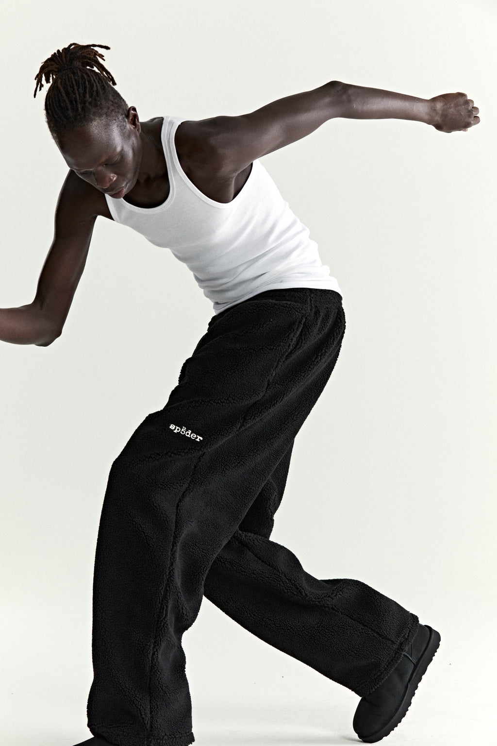 Black teddy fleece pant with white "sp5der" logo, elasticized waistband, and straight leg fit.
