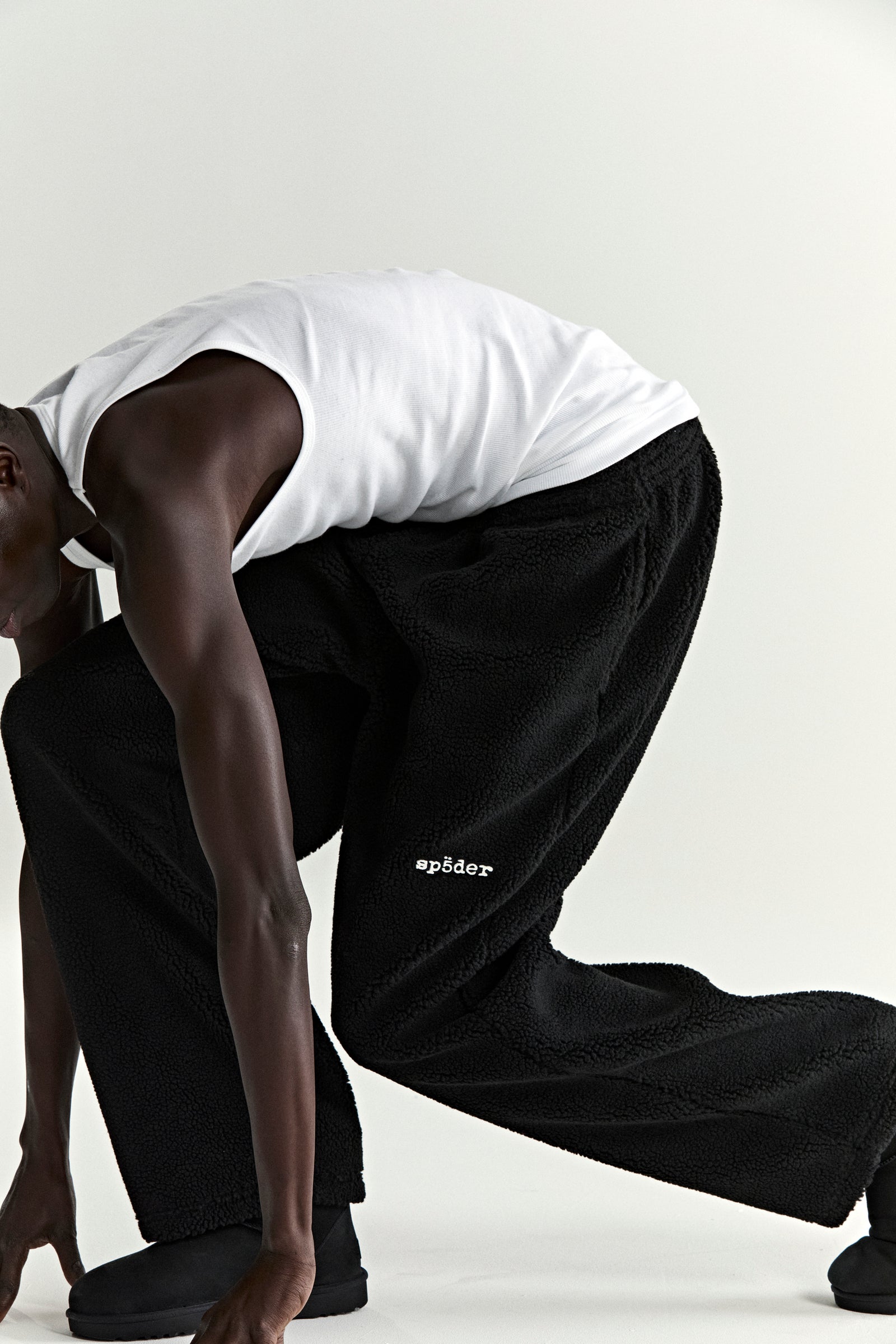 Black sherpa fleece pant with "spåder" logo patch, elasticized drawstring waist, and straight leg fit.