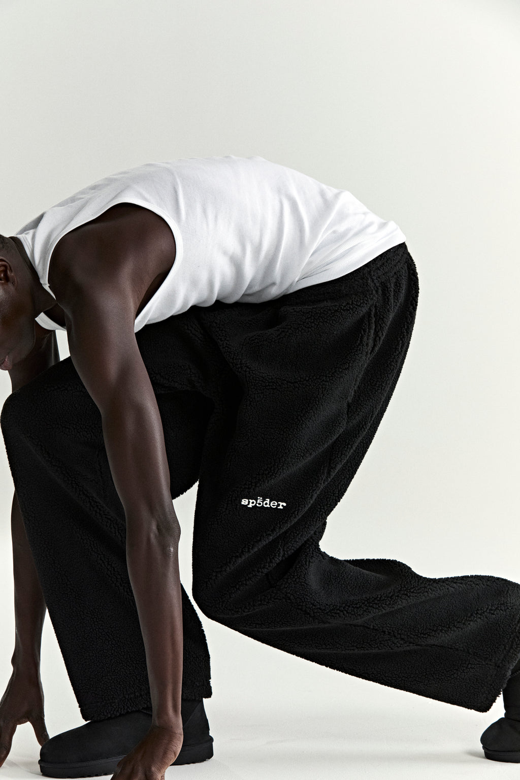 Black sherpa fleece pant with "spåder" logo patch, elasticized drawstring waist, and straight leg fit.
