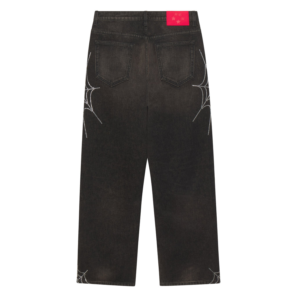 Faded black straight-leg denim jeans featuring rhinestone web graphic designs and a red branded leather back patch.