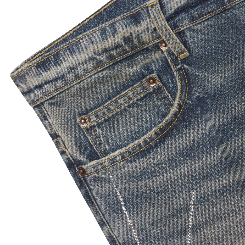 Faded blue 13oz denim jeans featuring a rhinestone web graphic design and custom branded copper hardware.