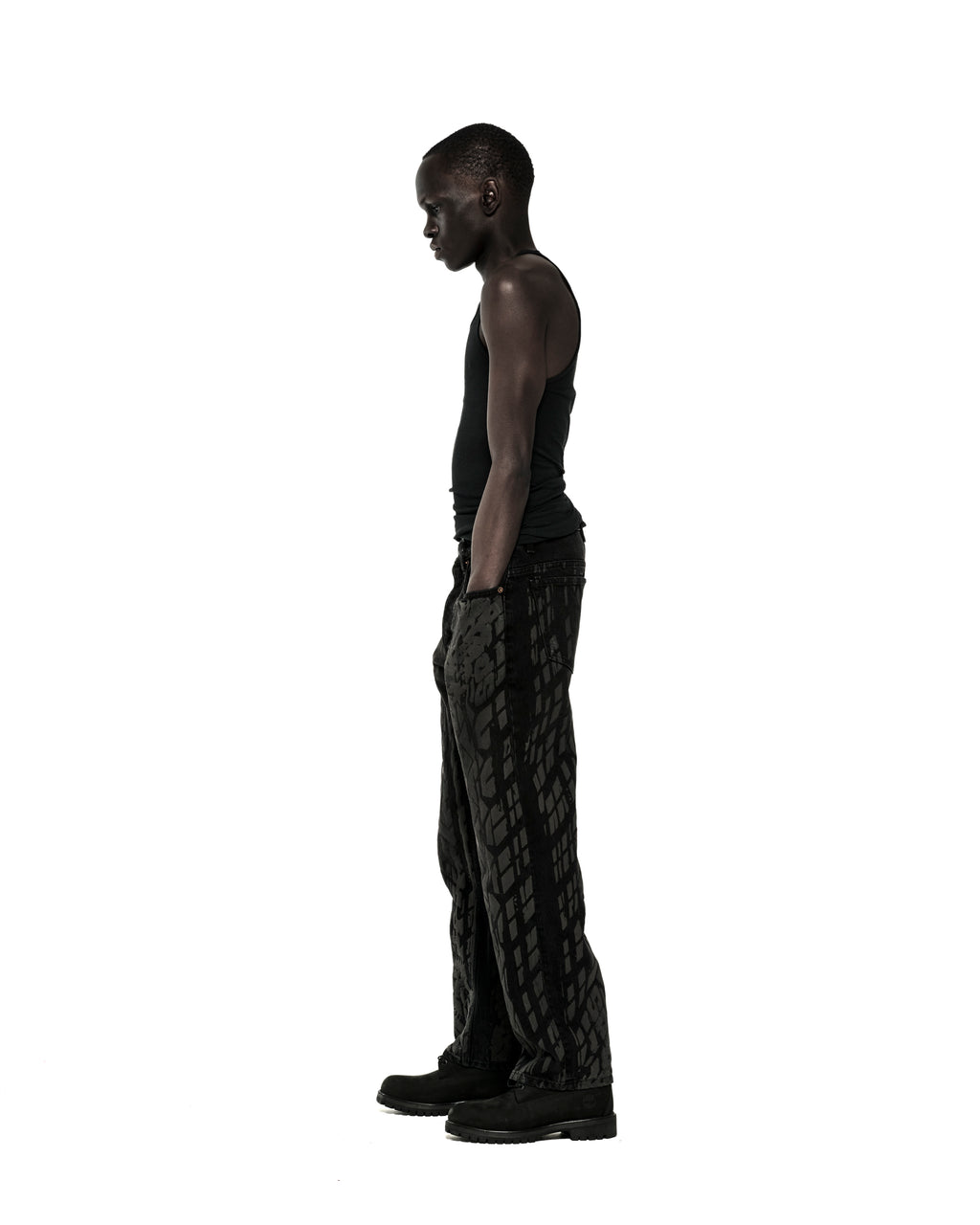 Model in black tank top and Burnout Denim pants with all-over tire track design, classic straight leg fit.