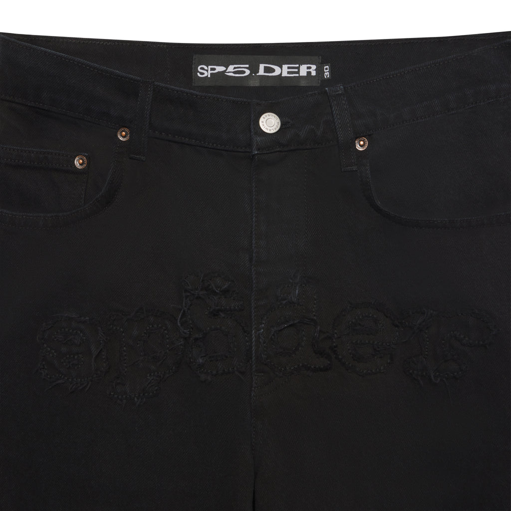 Black distressed denim jeans with frayed "SP5DER" logo, branded hardware, and shank buttons.