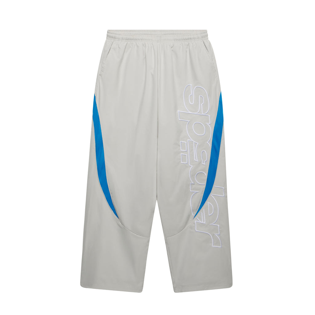 Grey nylon wide-leg track pants with blue contrast side panels, mesh accents, and large embroidered graphic text.
