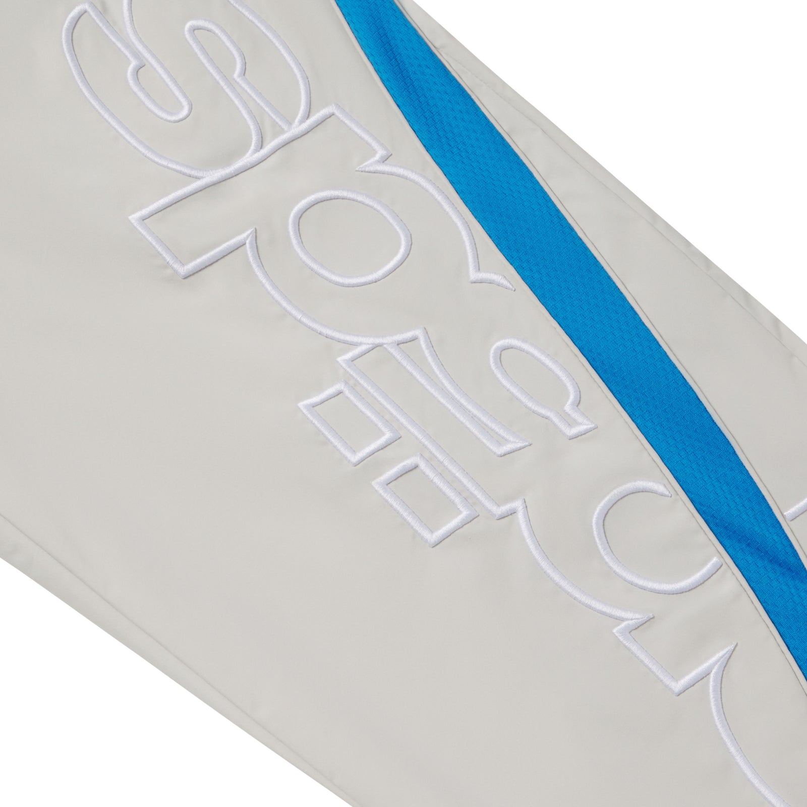 Light grey nylon track pant featuring a bright blue mesh side panel and white embroidered graphic text design.