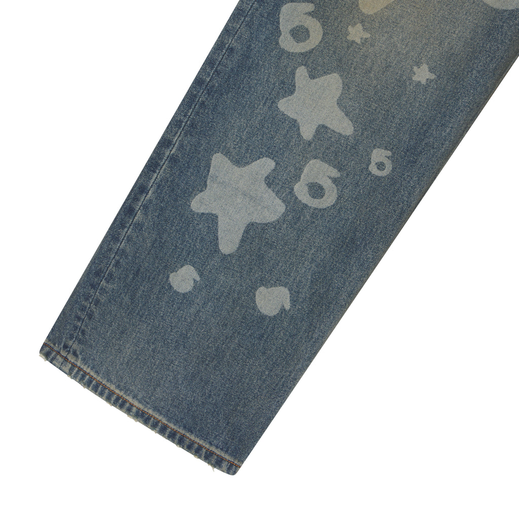 Straight-leg blue denim jeans featuring a faded white Beluga graphic print of stars and numbers.