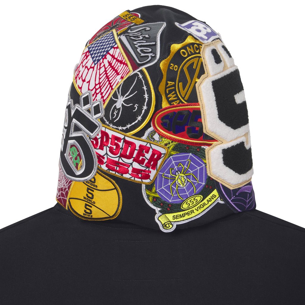 Black cotton fleece hoodie featuring a hood covered in colorful embroidered, woven, and chenille graphic patches.