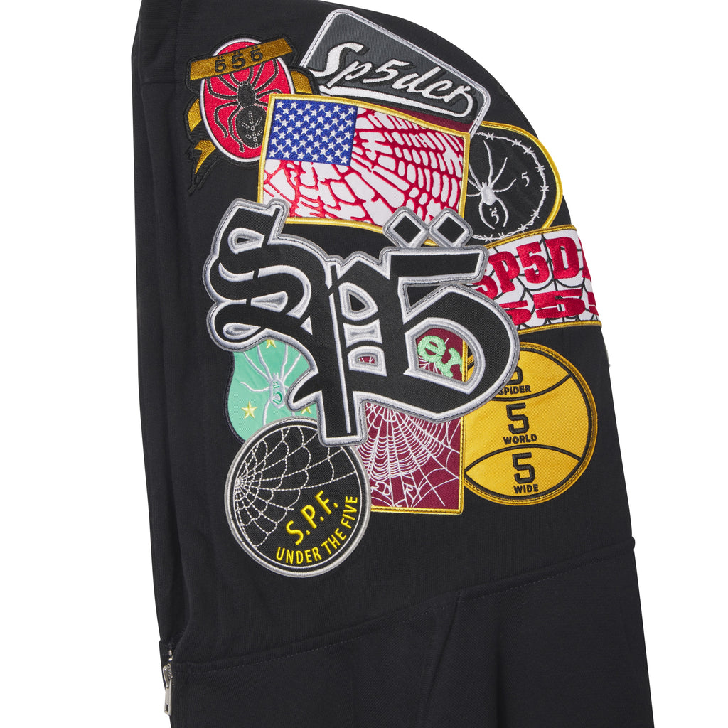 Black cotton fleece zip hoodie featuring a hood covered in colorful embroidered, woven, and chenille graphic patches.