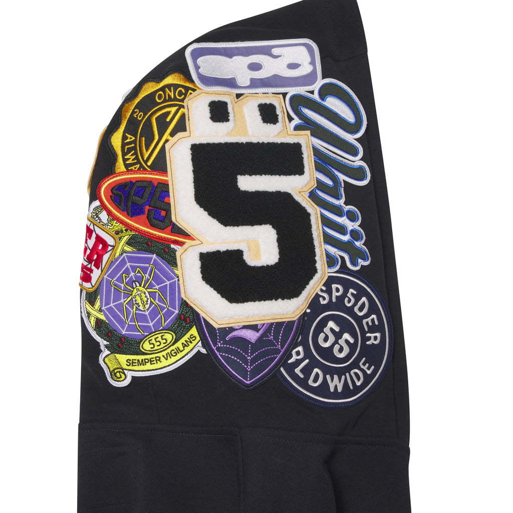 Black cotton fleece hoodie hood featuring colorful embroidered, woven, and chenille graphic patches.