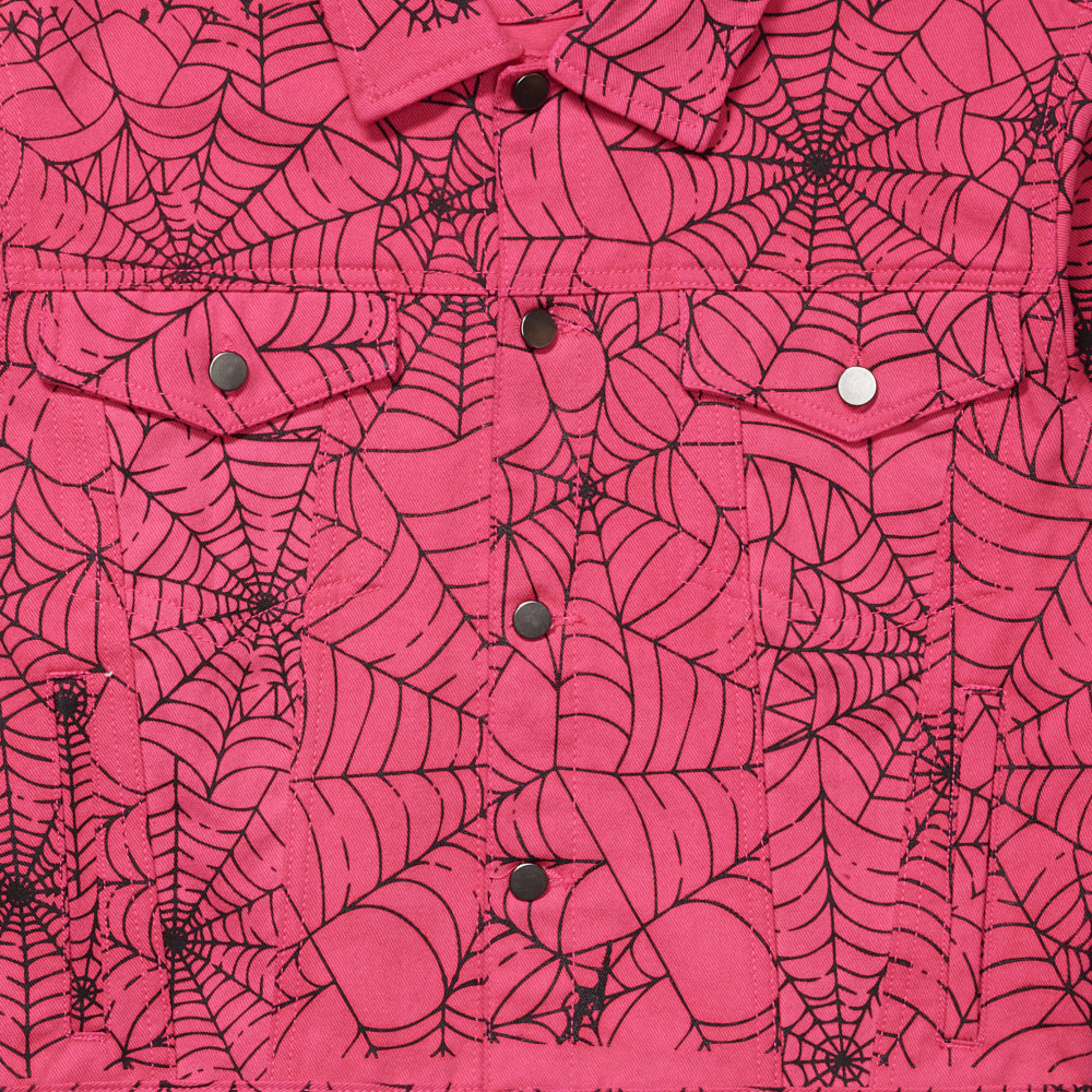 Pink denim trucker jacket with black spiderweb print, silver button closures, and two chest pockets.