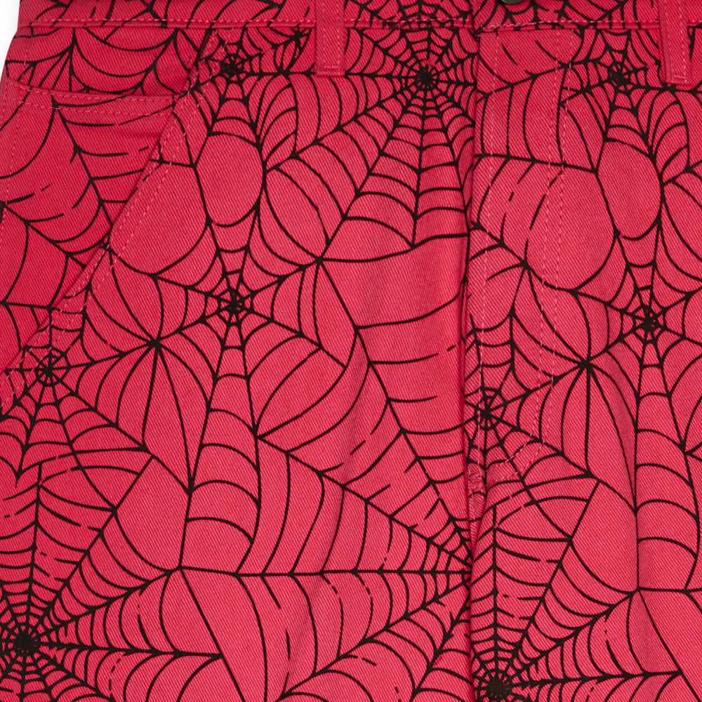 Pink denim work pants with an all-over black spider web print.