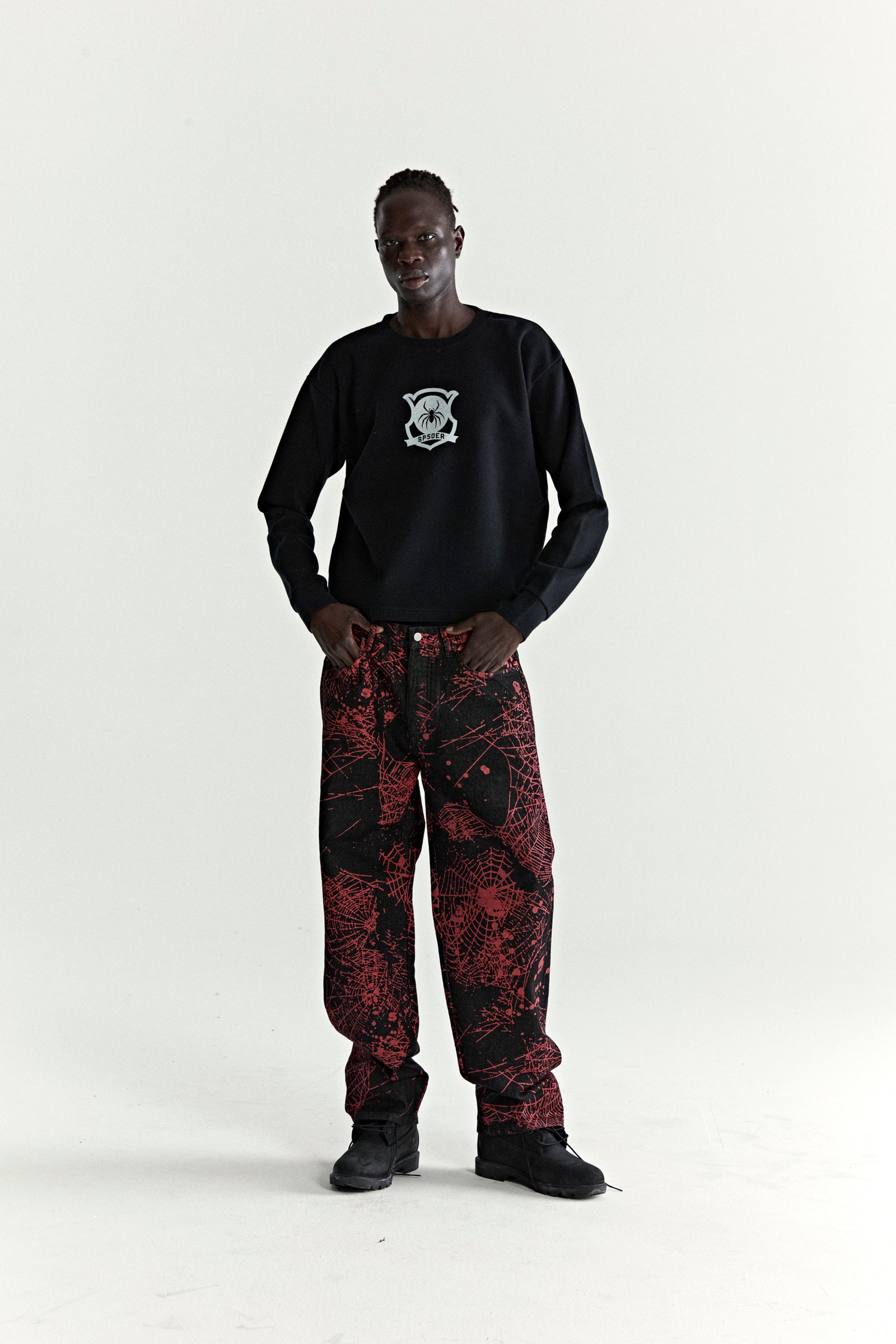 V2 WEB DENIM pants: black denim with all-over red web print, classic straight leg fit.