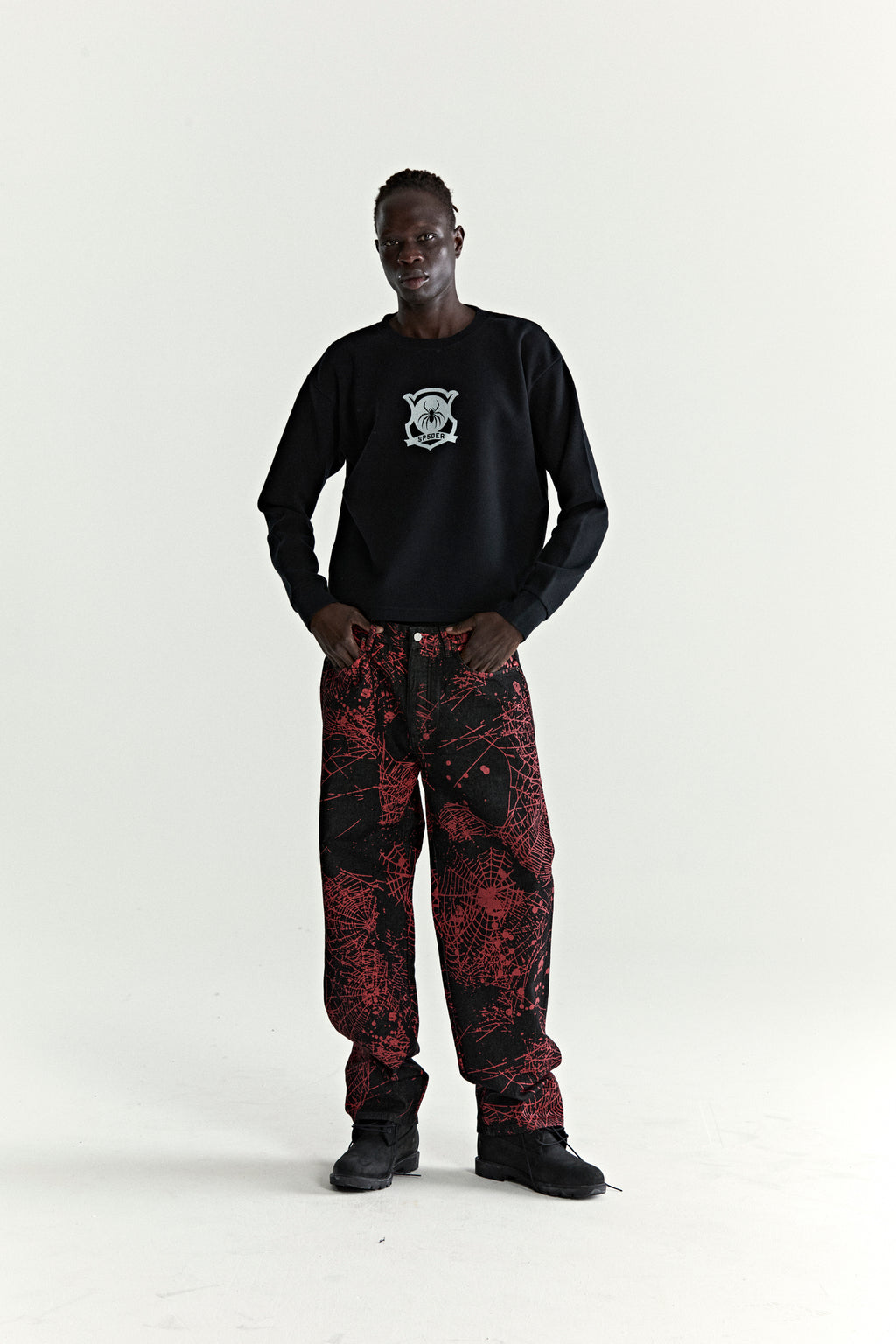 Black Beckham Thermal waffle knit shirt with graphic print, paired with black and red spiderweb pants.