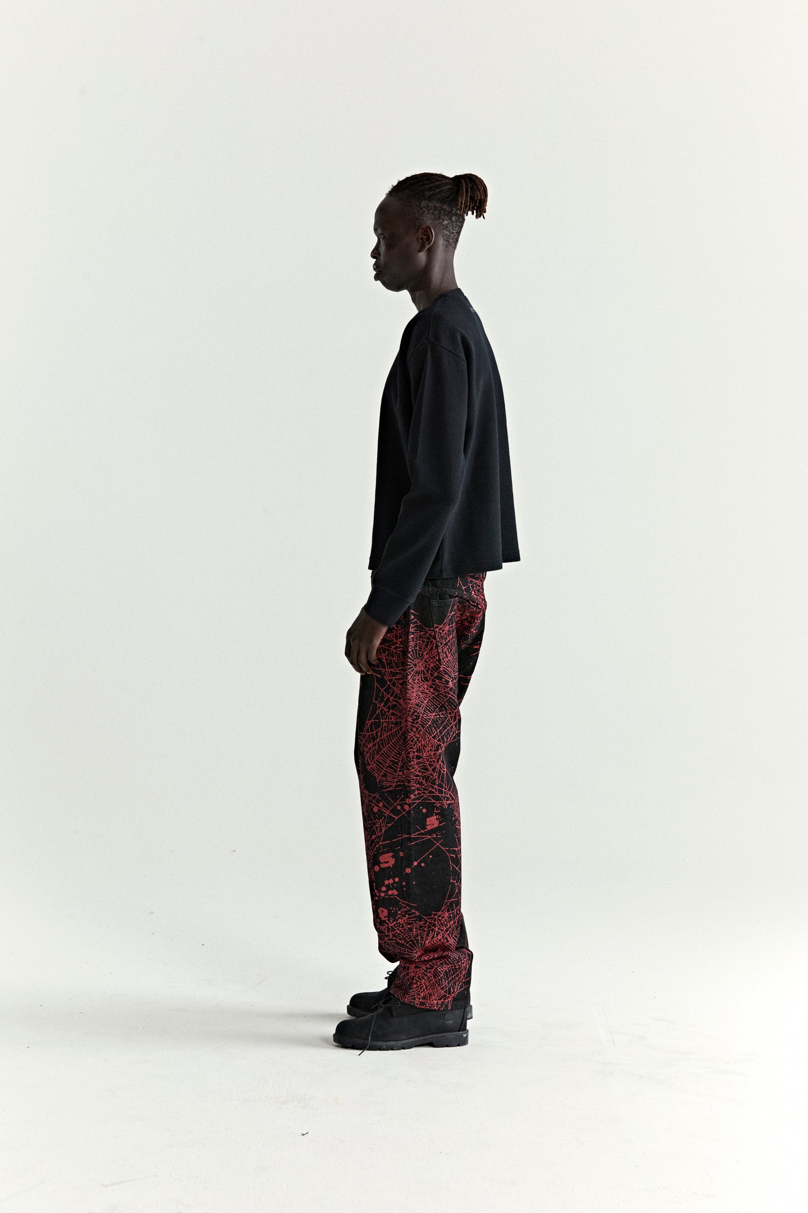 Man in black waffle knit Beckham Thermal and red graphic print pants.