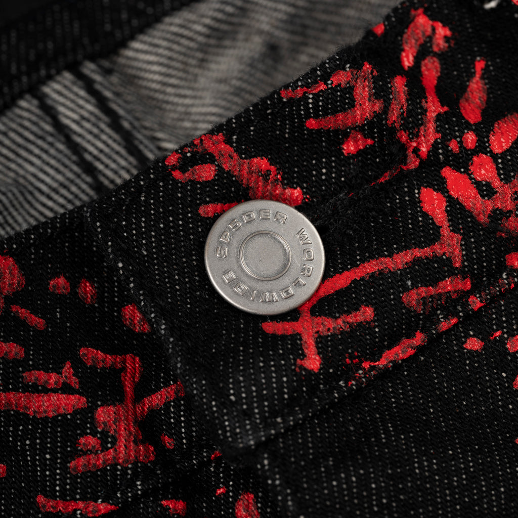 Black denim pants with red web print, featuring a silver SP5DER branded button.