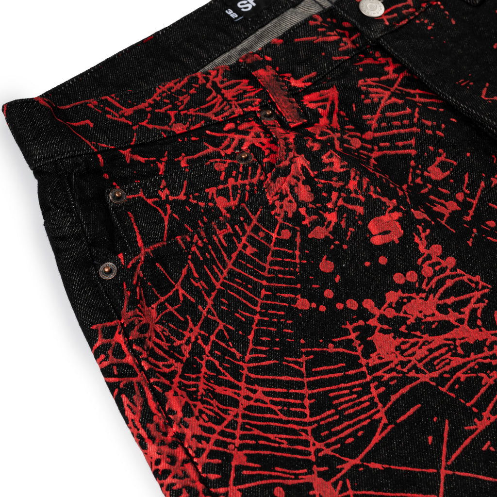 Black denim V2 WEB DENIM pants with all-over red web print, belt loops, and five-pocket styling.