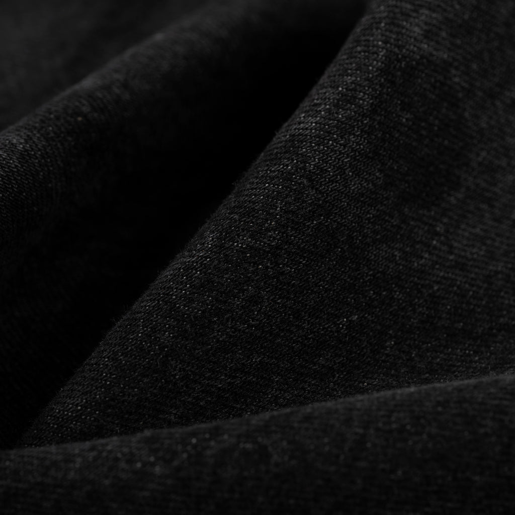 Close-up of dark, faded wash Beluga denim fabric with visible texture.