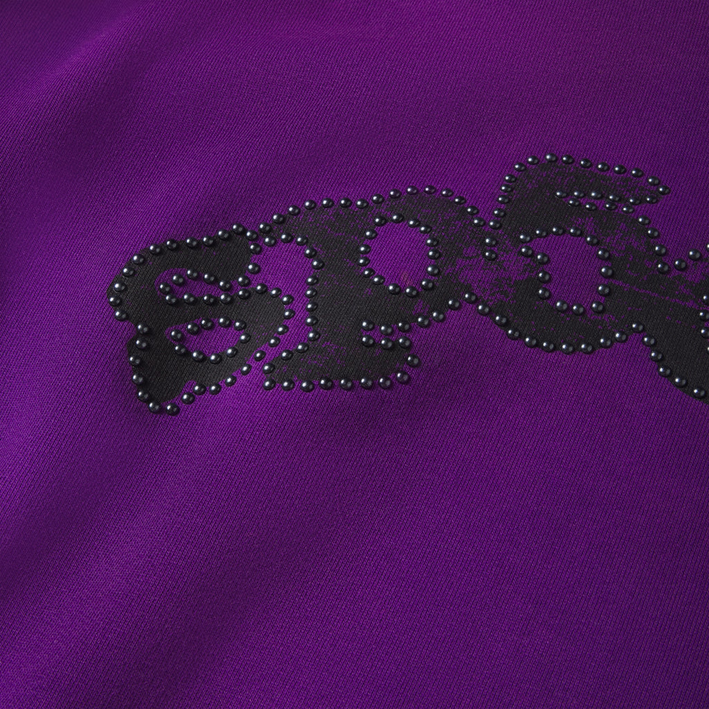 Purple 13oz cotton fleece hoodie featuring a black graphic OG logo outlined with metallic studs.