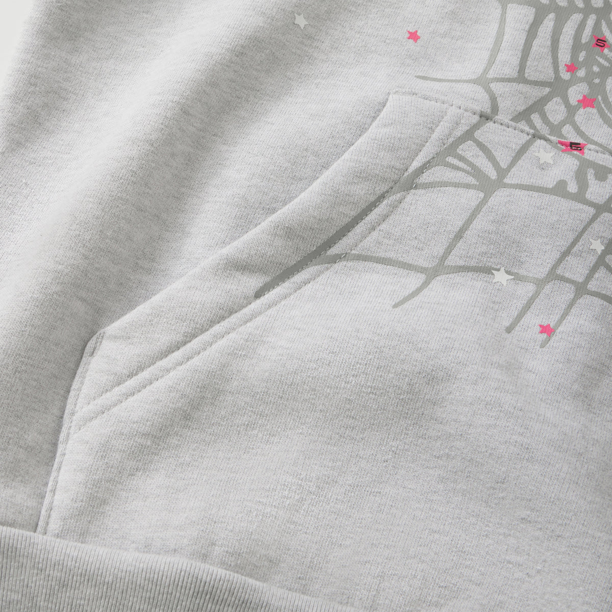 Grey cotton fleece hoodie featuring a web graphic print, pink star accents, and a front kangaroo pocket.