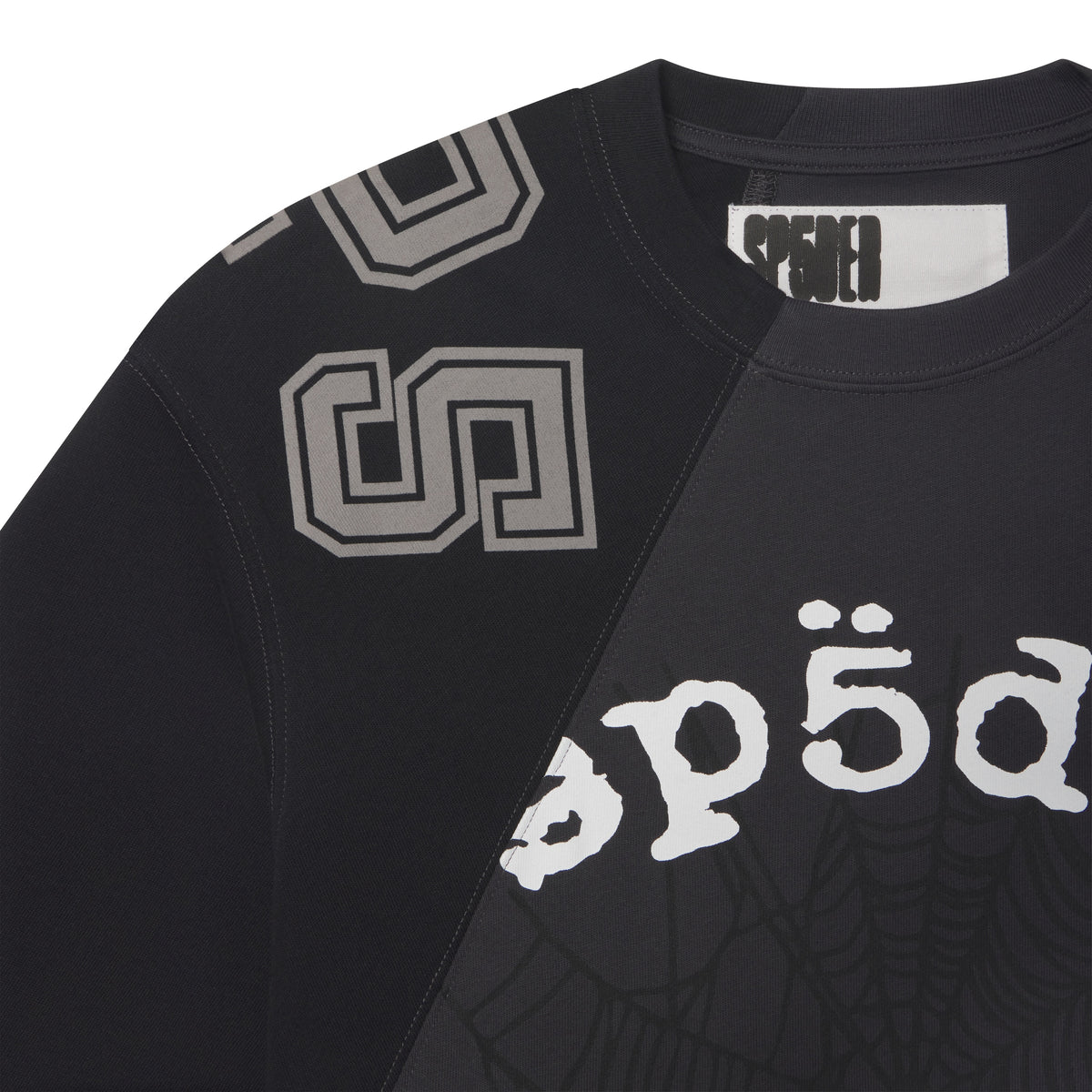 Black cotton crewneck tee with asymmetrical color-block panels, collegiate-style lettering, and web graphic prints.