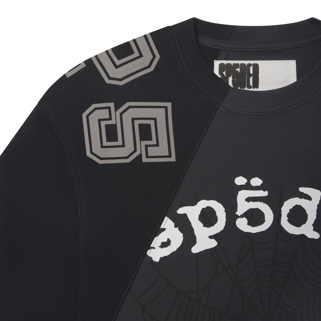 Black cotton crewneck tee with asymmetrical color-block panels, collegiate-style lettering, and web graphic prints.