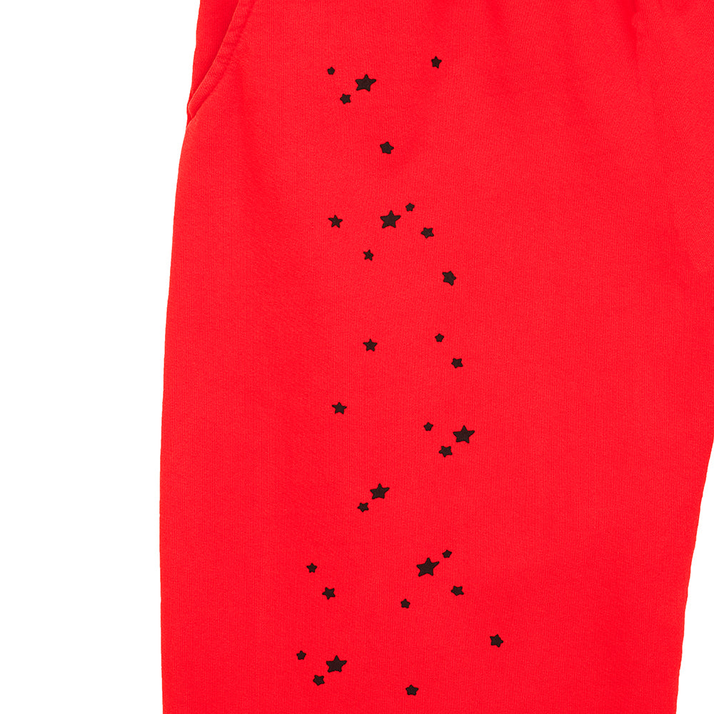 Red P*NK V2 sweatpants with black star prints and SP5DER motif down the leg.