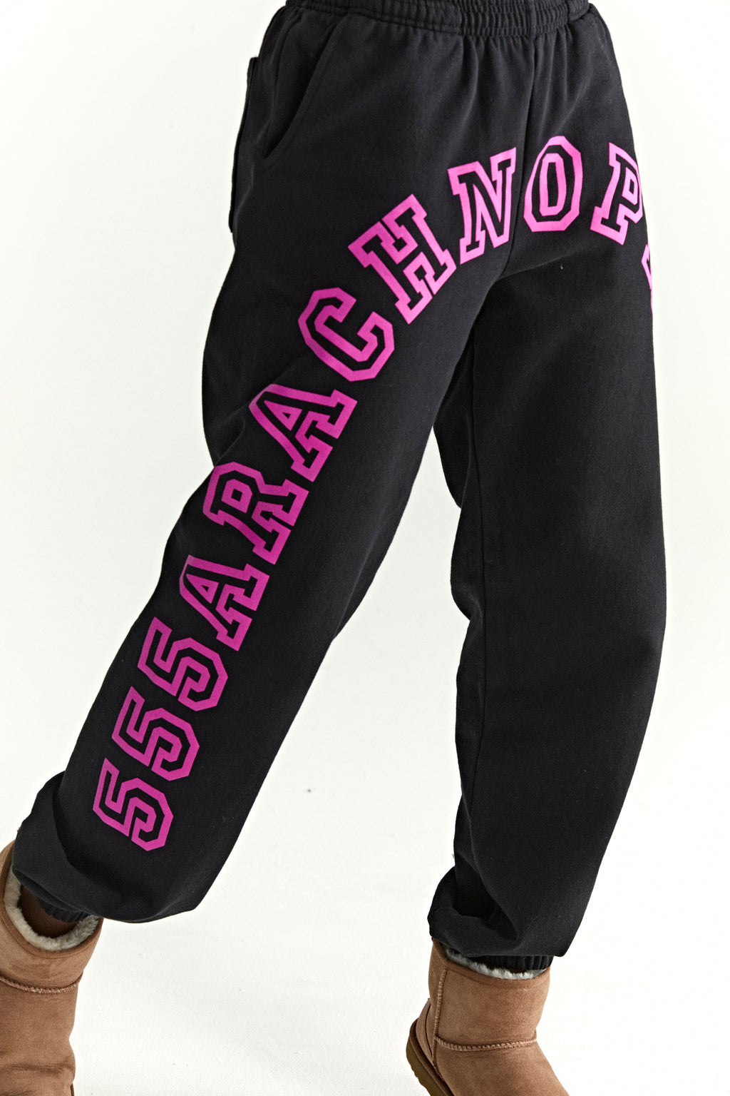 Black ARACH SWEATPANT with arched pink puff print text along crotch and leg, elasticized waistband and cuffs.