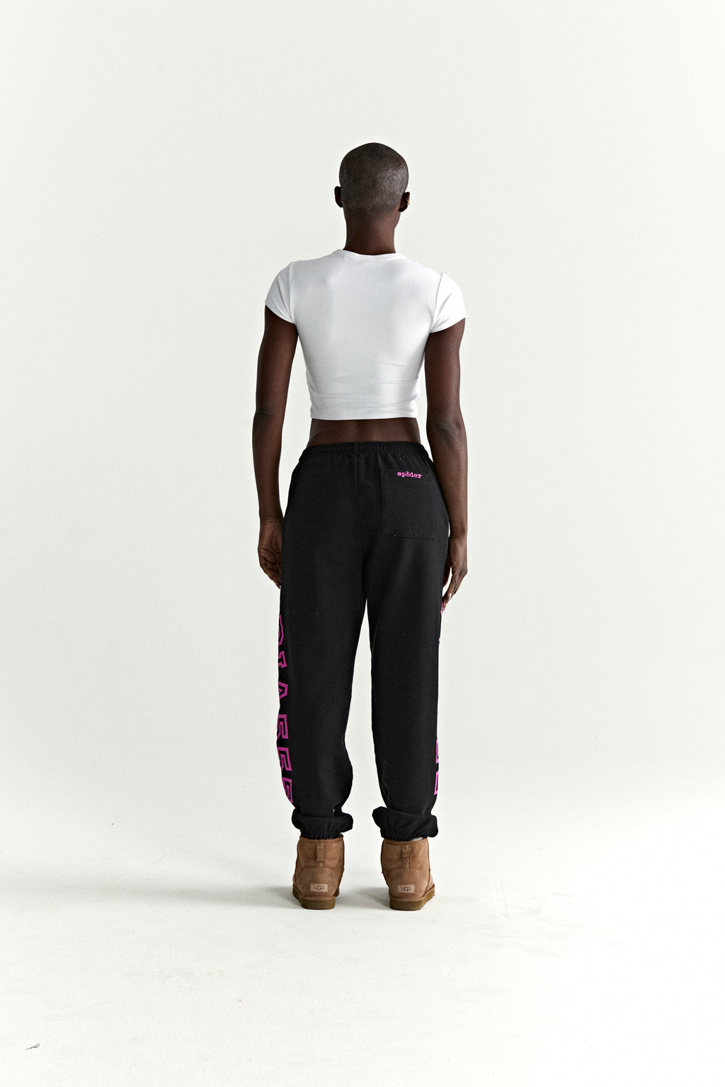 Black ARACH SWEATPANT, 100% cotton fleece, with pink arched text print along crotch and leg.