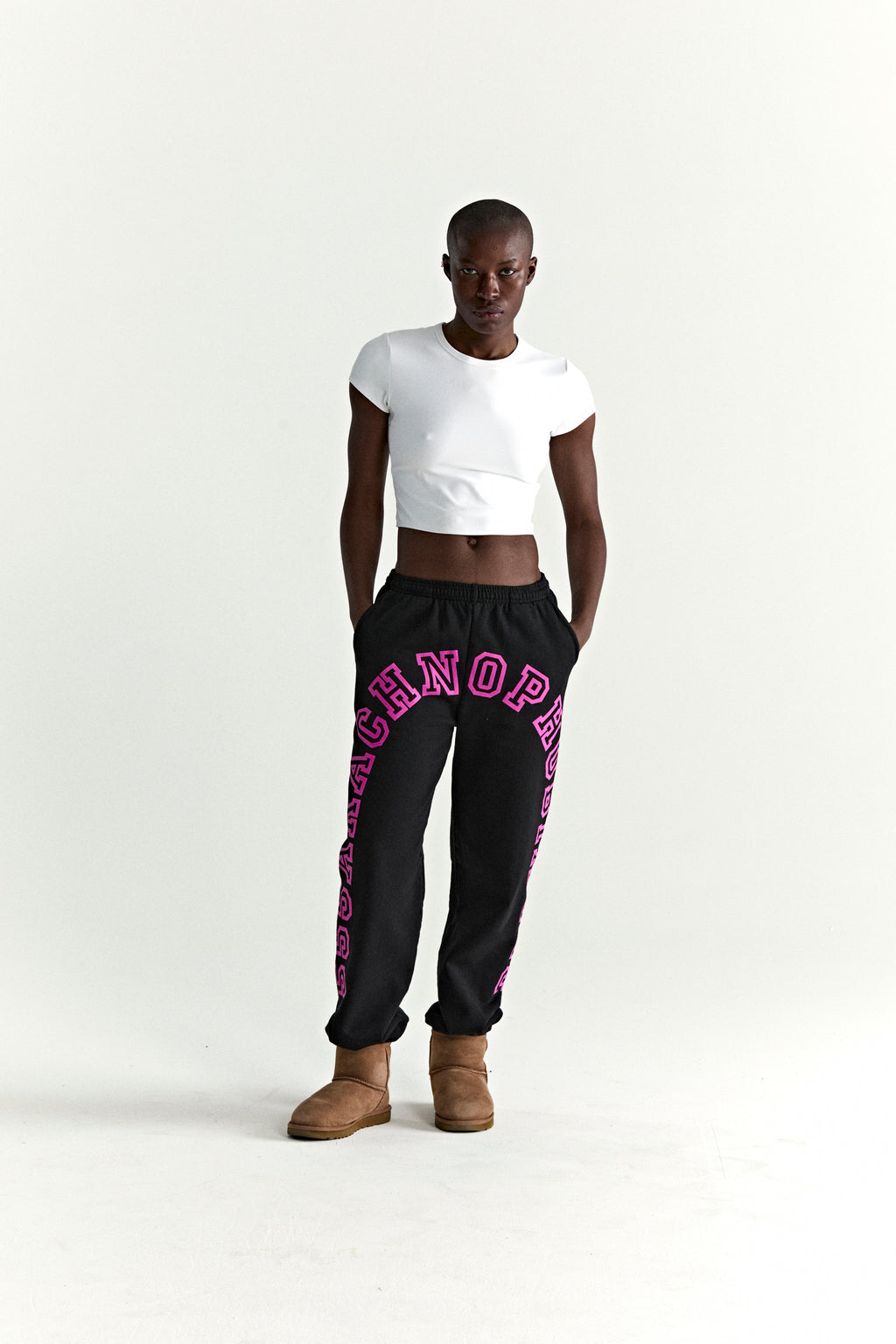 Black ARACH SWEATPANT with pink arched text print, elasticized waistband, and cuffs, worn by a model.